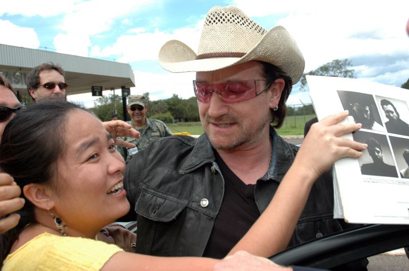 Bono, líder do U2, desce do carro para conversar com fãs, em frente à Base Aérea de Brasília. Foto de Breno Fortes (19/02/2006)  